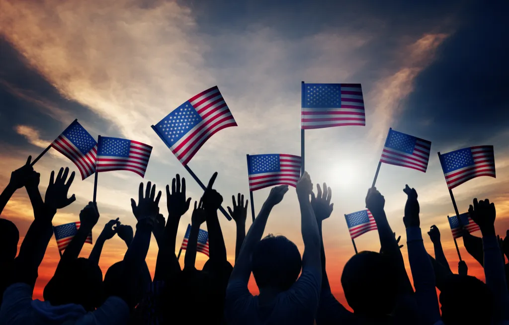 Люди с американскими флагами в поднятых руках