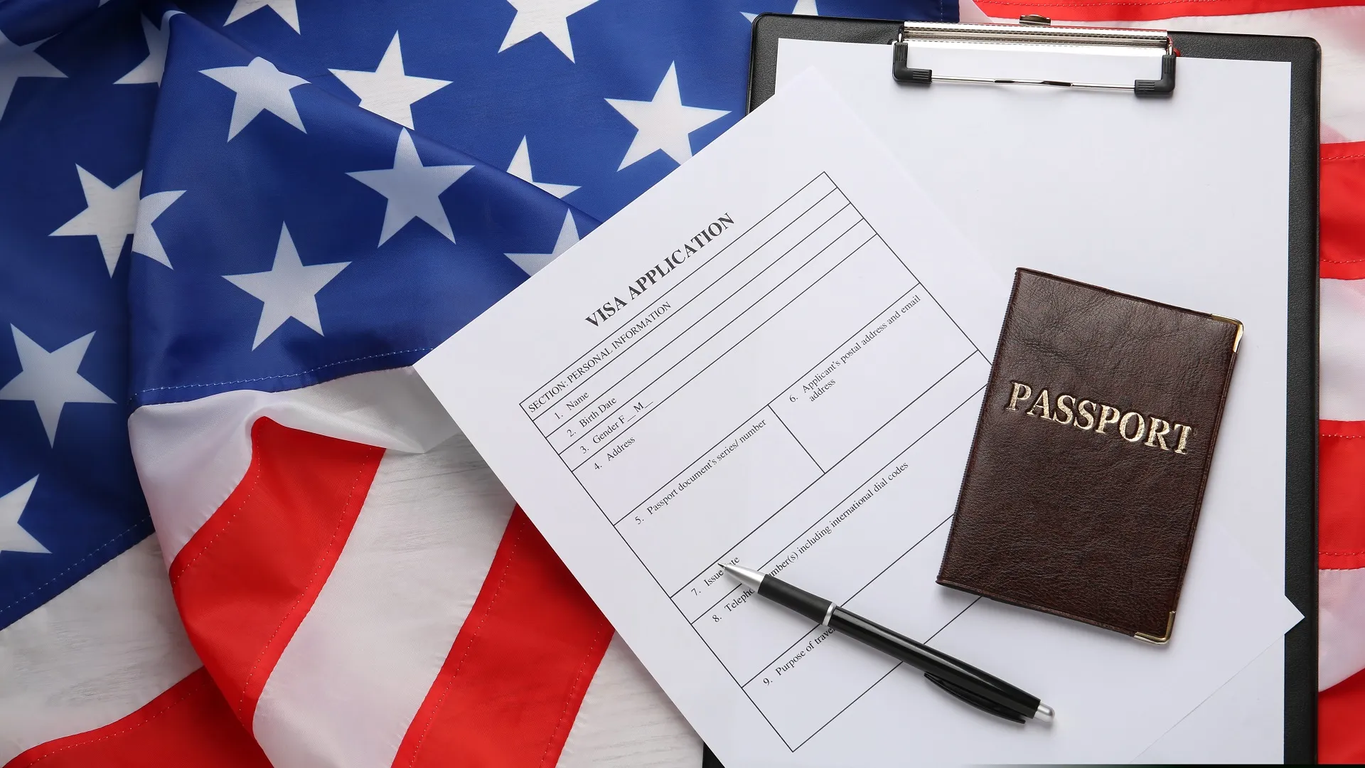 Паспорт и анкета на визу на фоне флага США