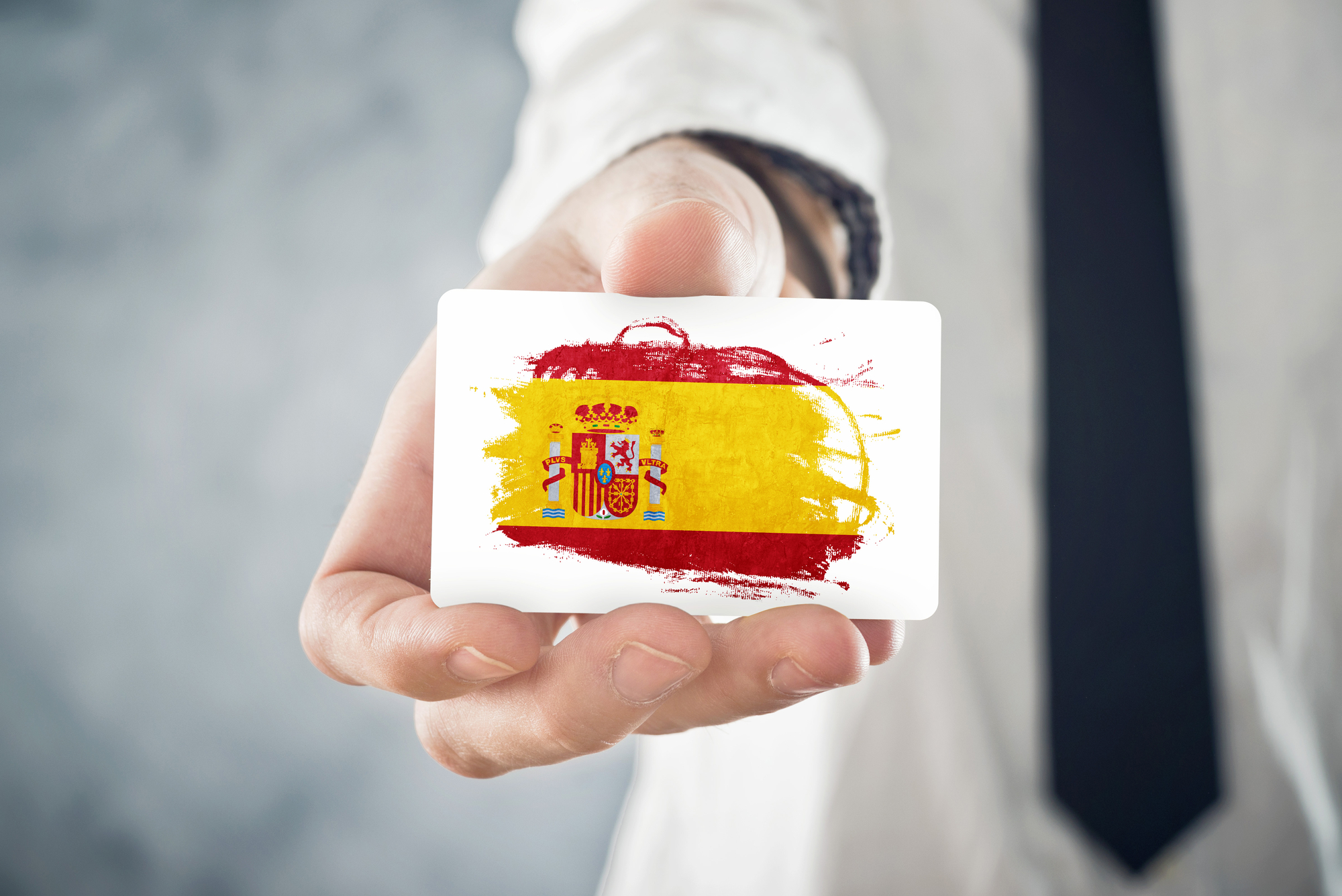 Карточка с флагом Испании в руке человека